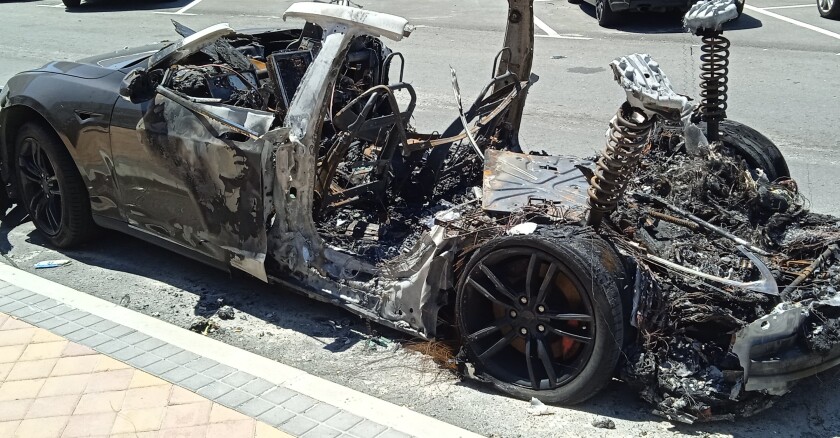 The burned out hull of an electric vehicle after a fire.